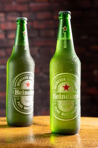 Garrafa de cerveja Heineken sobre madeira rústica