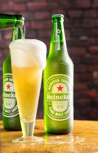 Garrafa de cerveja Heineken sobre madeira rústica