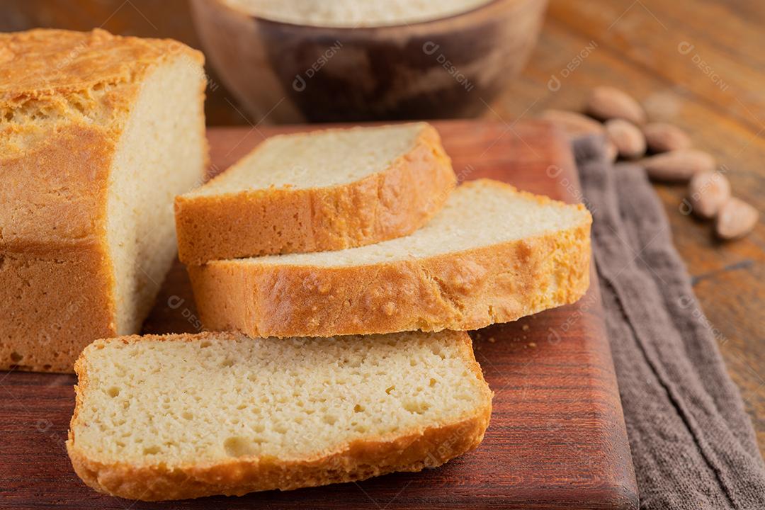 Pão de farinha de amêndoa fatiado sobre tábua de madeira