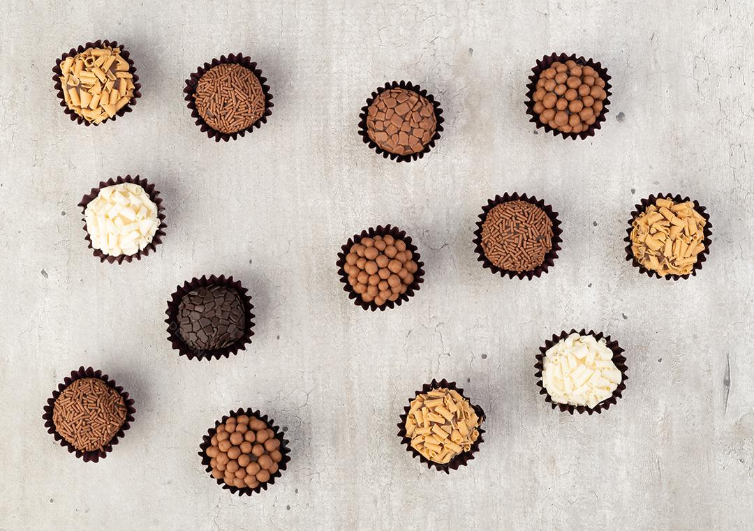 Brigadeiros típicos brasileiros, vários sabores em uma mesa de madeira