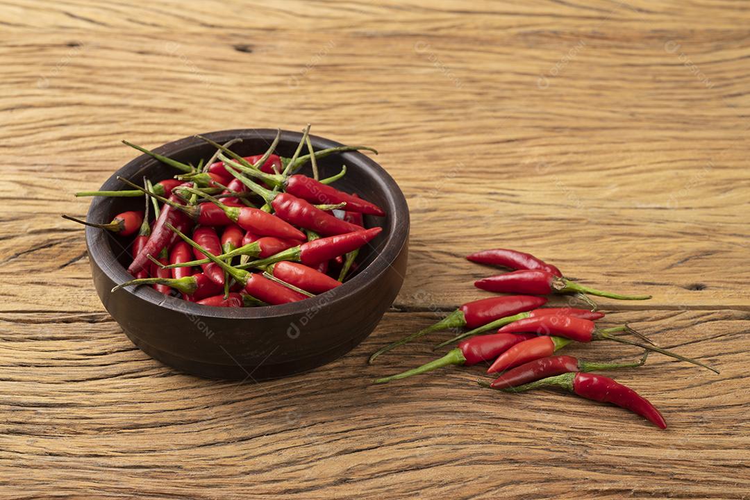 Pimentão vermelho malagueta em uma tigela sobre mesa de madeira