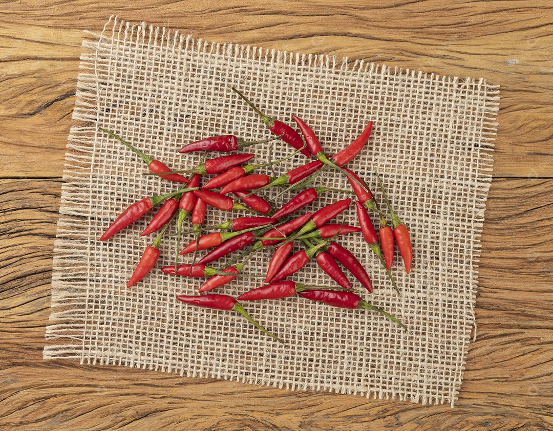 Pimentão malagueta vermelho em um tecido rústico sobre mesa de madeira