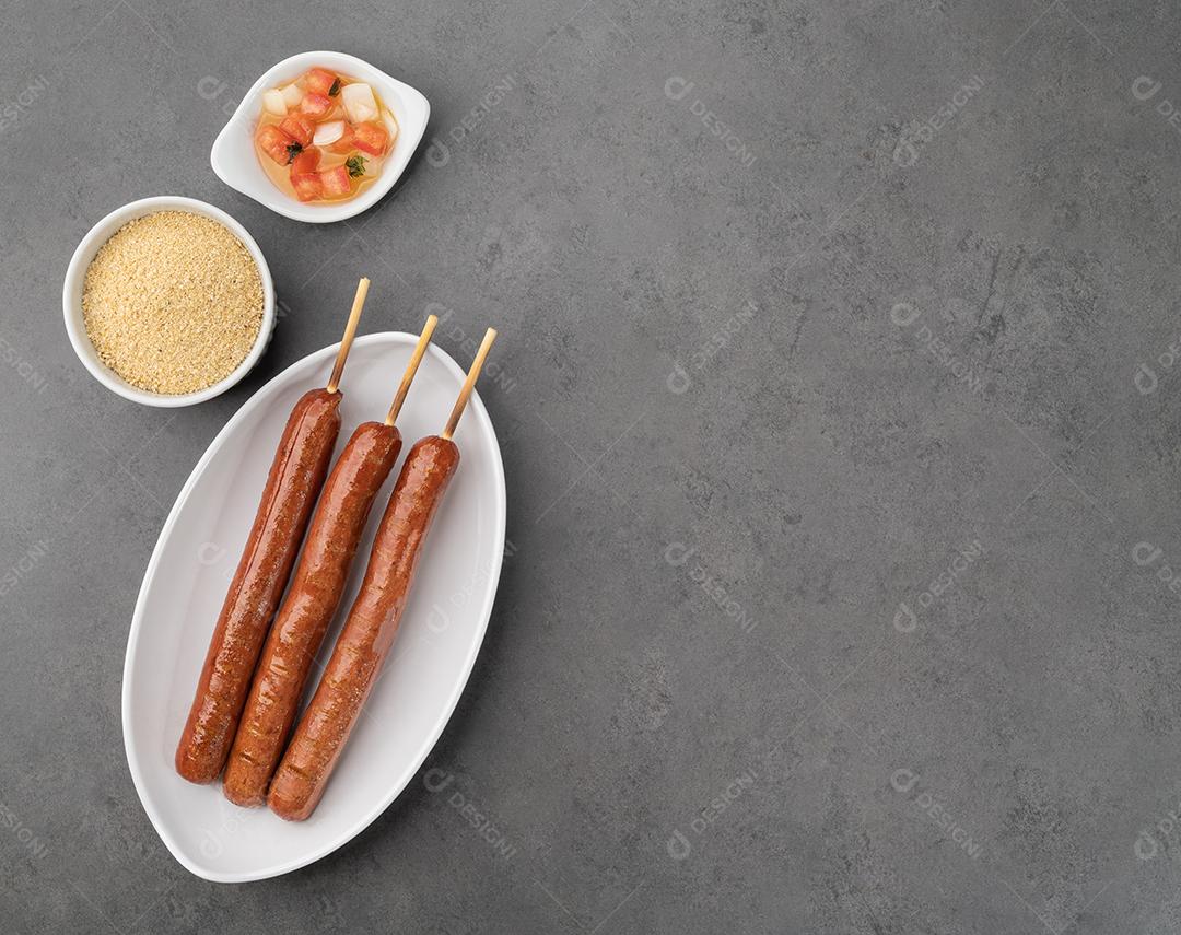 Espetos de salsicha de porco com farofa, vinagrete