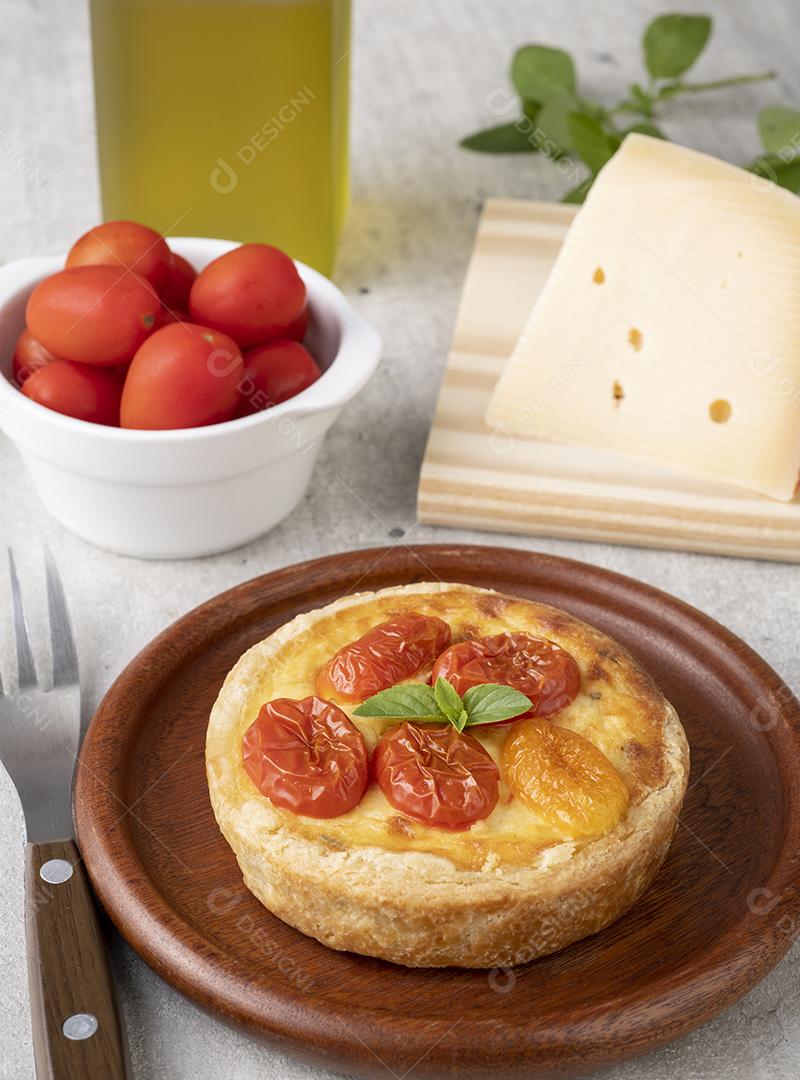 Quiche caprese caseiro sobre prato de madeira com ingredientes