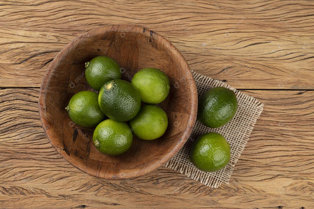 Limões em uma tigela sobre mesa de madeira