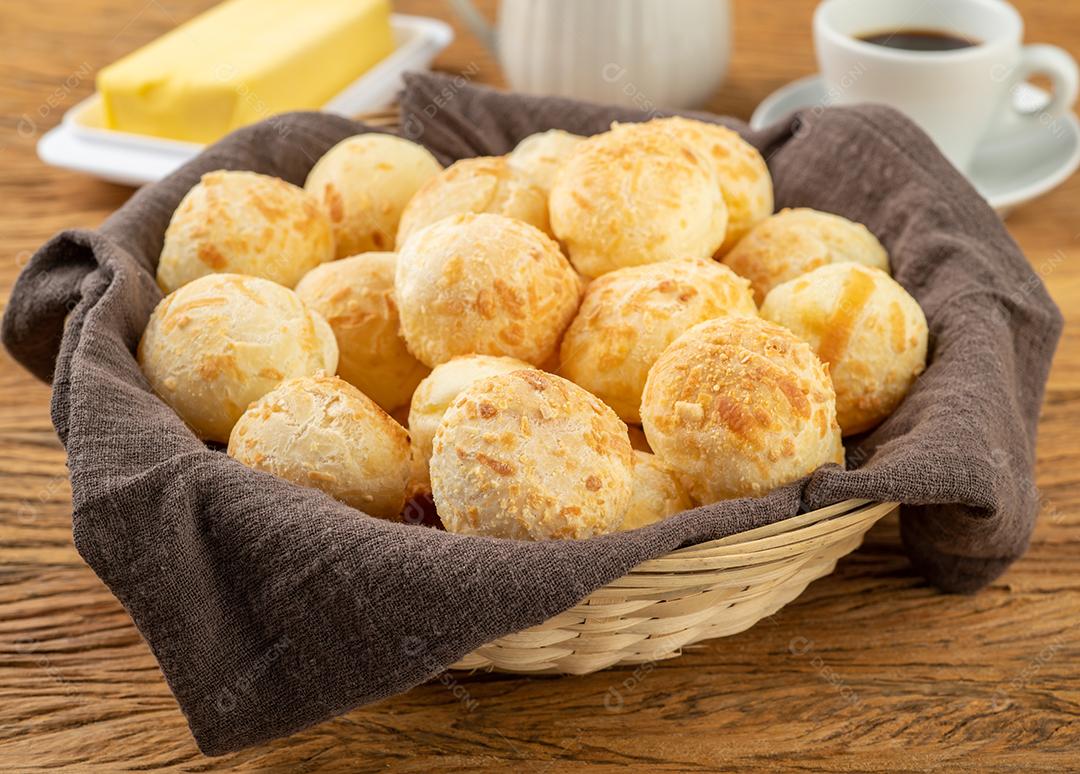 Pão de queijo típico brasileiro em uma cesta, café e manteiga