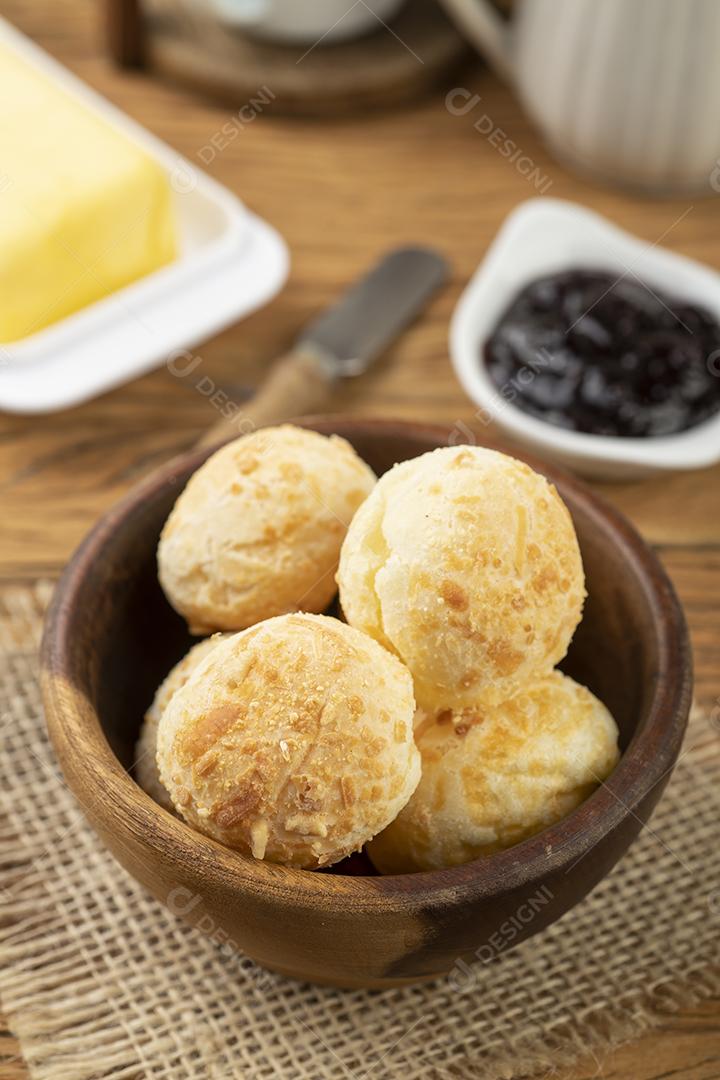 Pão de queijo típico brasileiro em uma cesta, café, geleia e manteiga