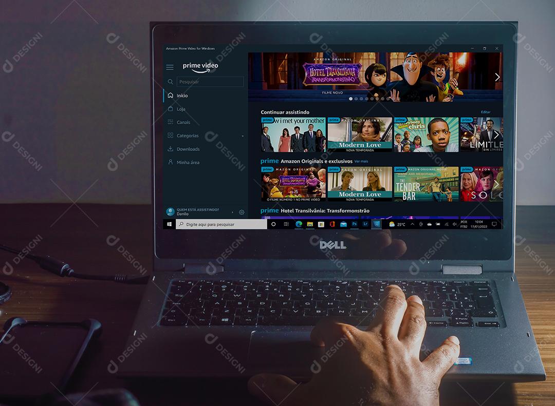 Pessoa mechendo em seu notebook usando prime video