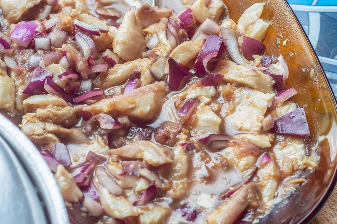 Sashimi de tilápia com cebola roxa, limão e gengibre, misturado com filé de tilápia fatiado.