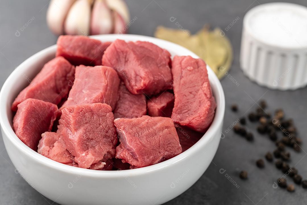 Carne picada em uma tigela com temperos sobre pedra