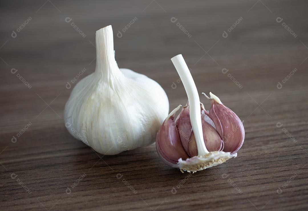 Bulbo de alho e cravo sobre fundo de madeira