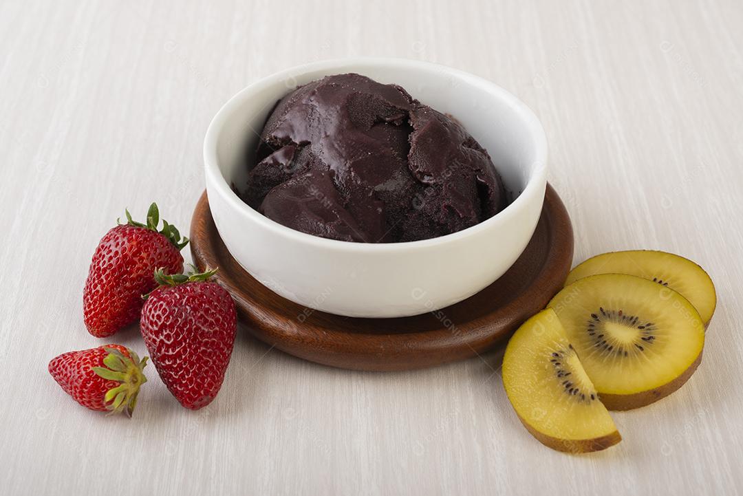 Tigela de açaí típica brasileira com frutas sobre fundo de madeira