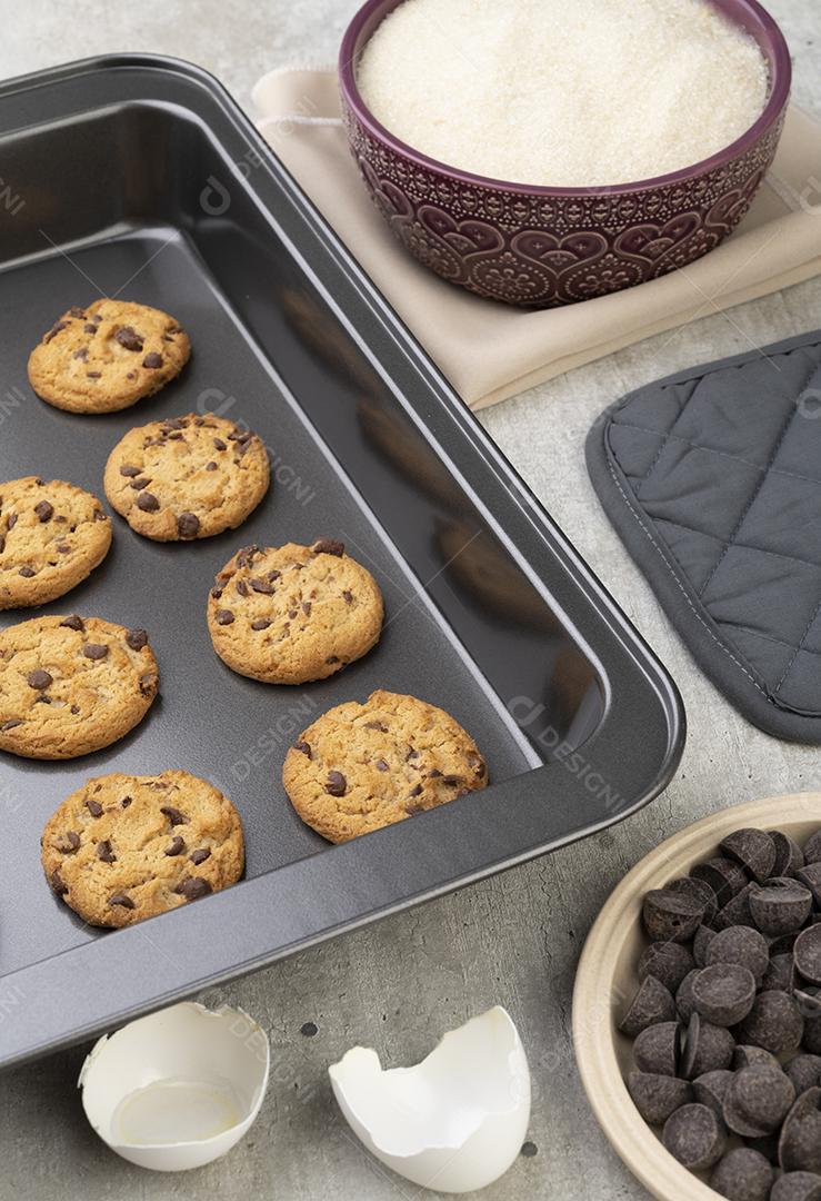 Chocolate chip cookies on a baking sheet with ingredients