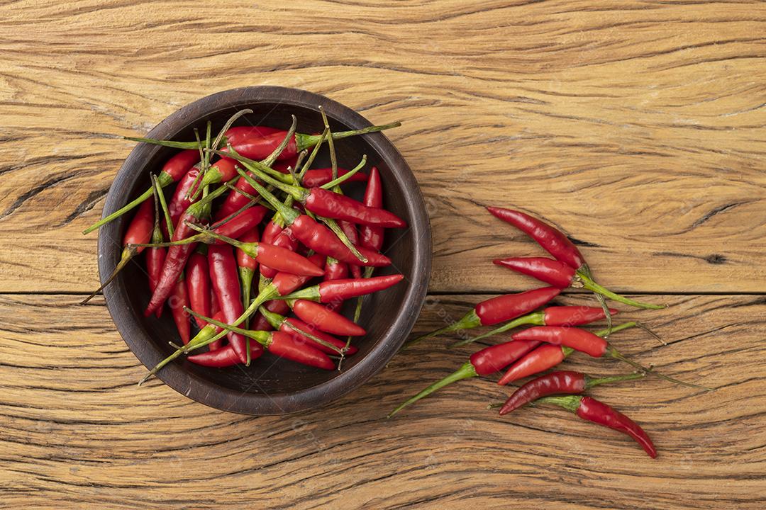 Pimentão vermelho malagueta em uma tigela sobre mesa de madeira