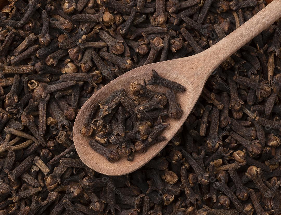 Top view cloves in a wooden spoon. food backdrop