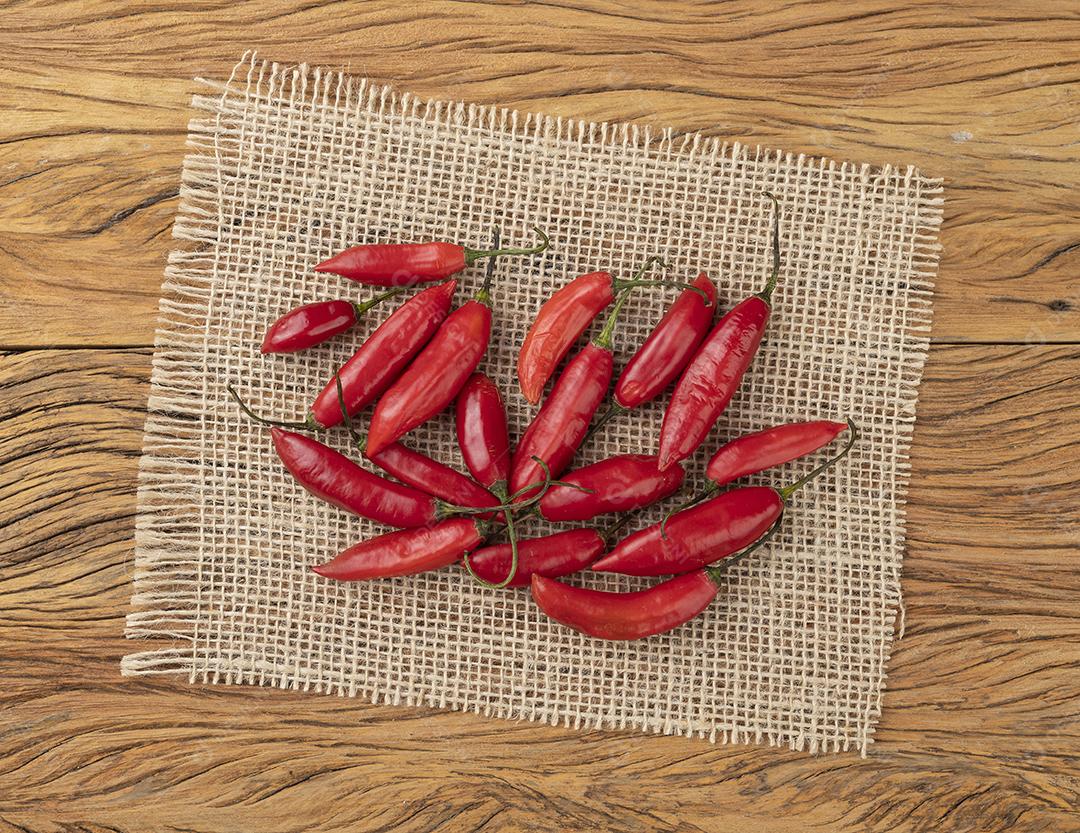 Pimentão vermelho em um tecido rústico sobre mesa de madeira