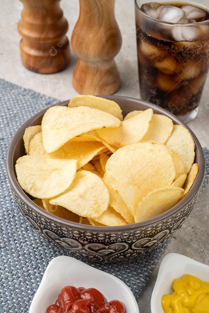 Batatas fritas em uma tigela, pimenta, sal, mostarda, ketchup