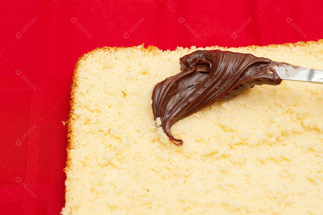 Recheio de bolo caseiro com ganache de chocolate. Isolado em fundo vermelho