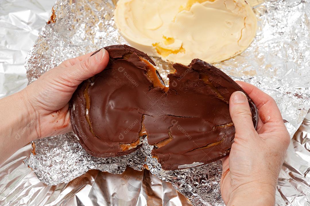 Ovo de Páscoa - Mãos desembalando ovo de chocolate caseiro embrulhado em papel alumínio