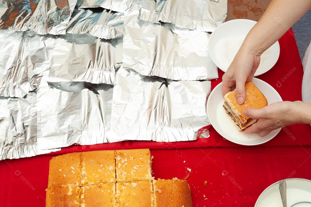 Bolo tradicional brasileiro chamado BOLO GELADO em português do Brasil - Fazendo passo a passo: Bolo de mão de mulher mergulhando no leite. Vista do topo. Tiro horizontal