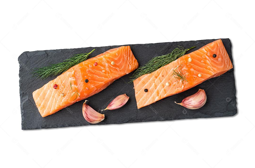 Fatias de salmão cru com temperos sobre tábua de pedra isolada sobre