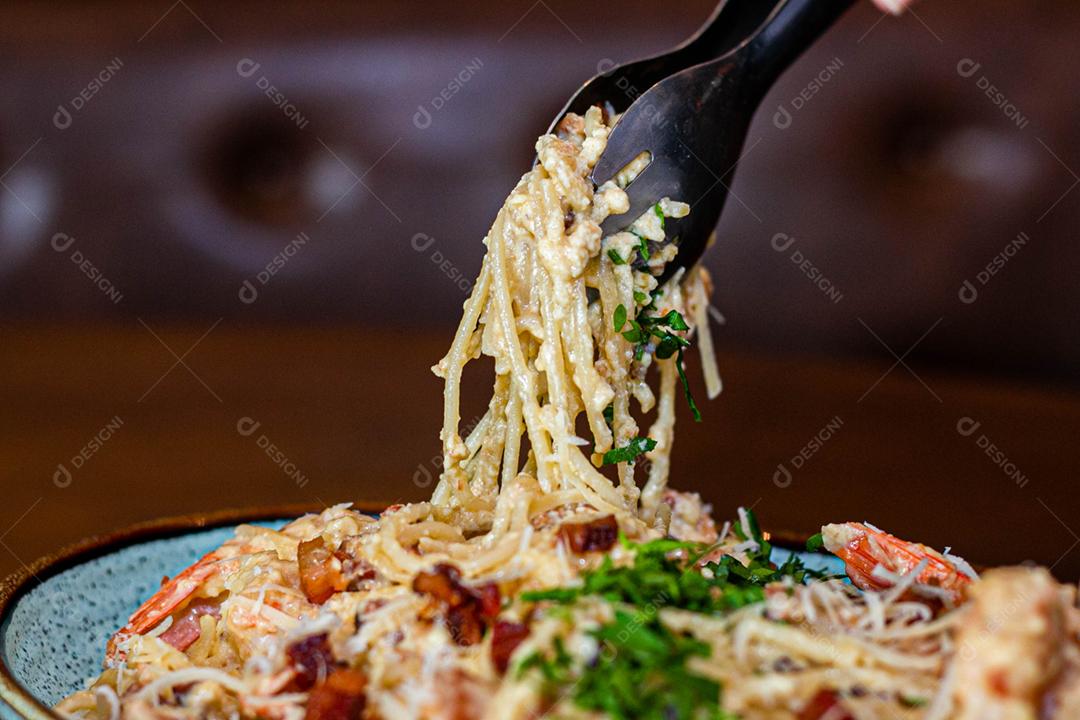 Prato de comida Espaguete ao alho e óleo sobre mesa de madeira