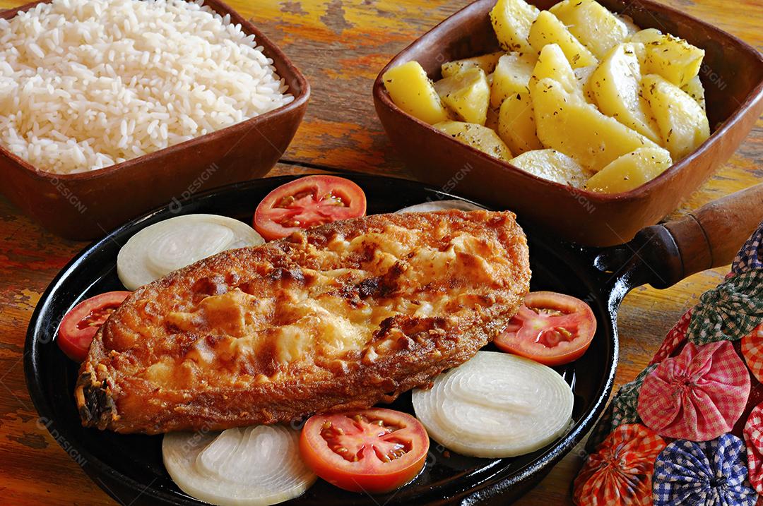 Peixe frito no bife com cebola e tomate, com arroz e batatas. Prato típico do nordeste brasileiro.