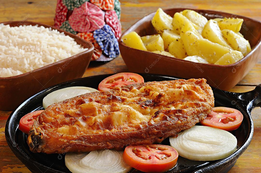 Peixe frito no bife com cebola e tomate, com arroz e batatas. Prato típico do nordeste brasileiro