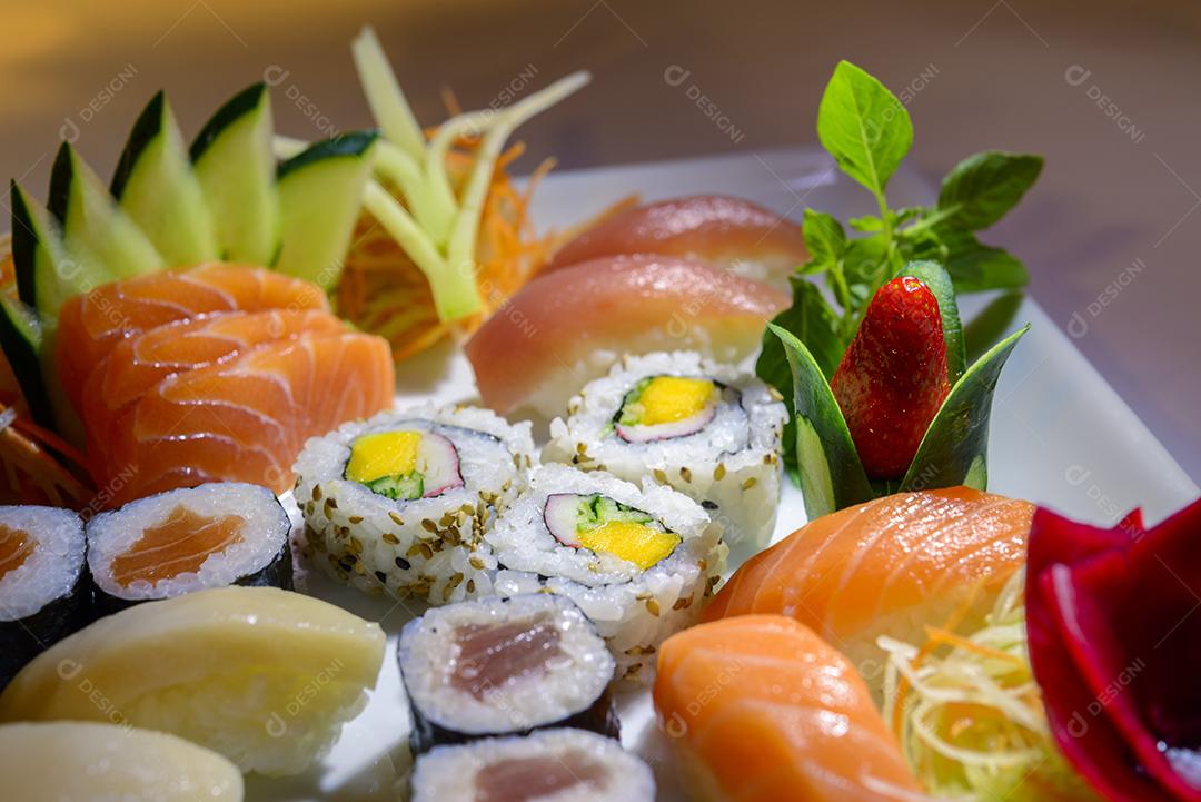 Mistura de comida japonesa, incluindo sushi e sashimi no prato branco
