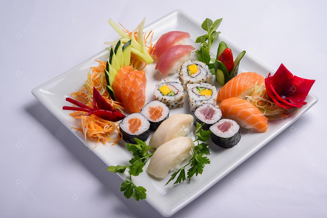 Mistura de comida japonesa, incluindo sushi e sashimi no prato branco