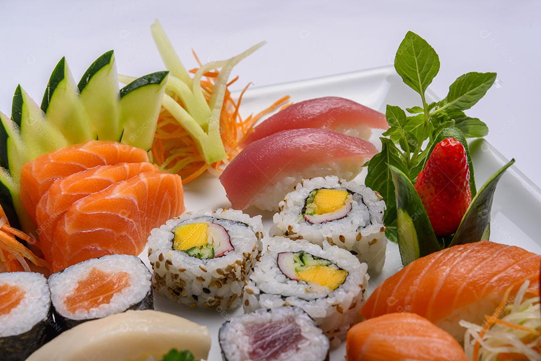 Mistura de comida japonesa, incluindo sushi e sashimi no prato branco