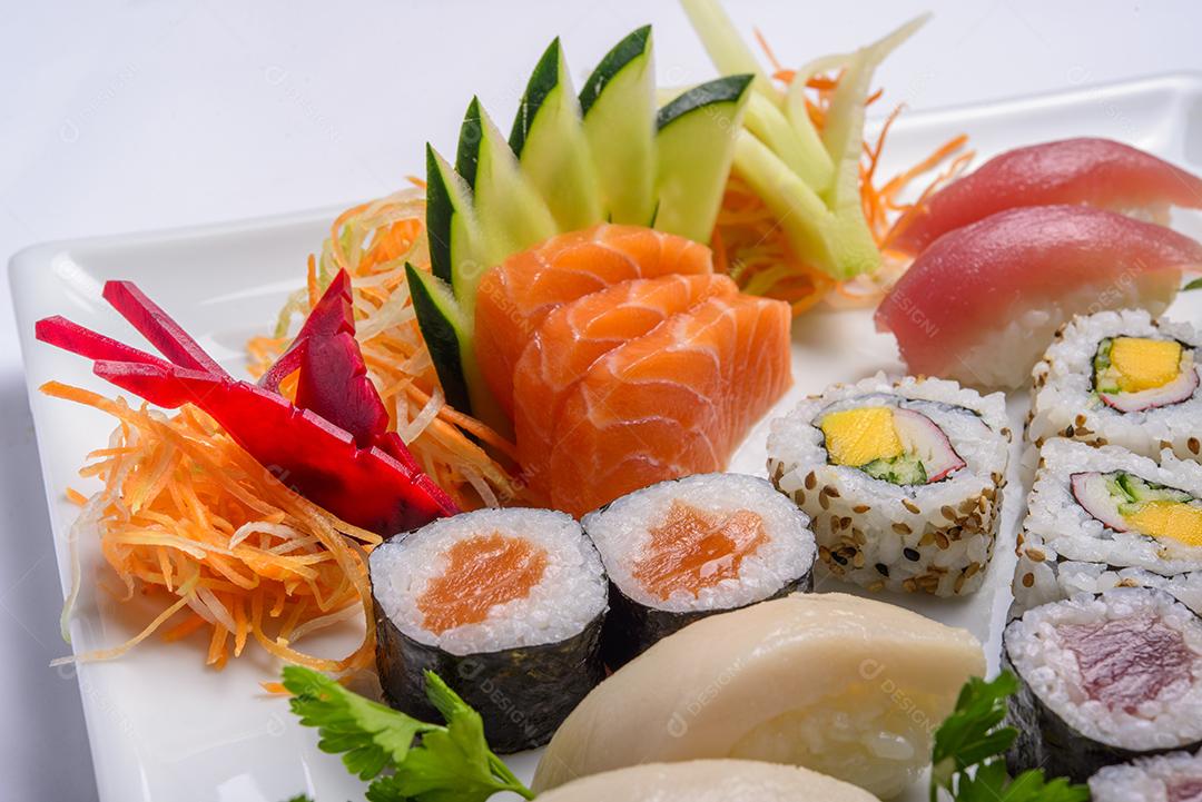 Mistura de comida japonesa, incluindo sushi e sashimi no prato branco