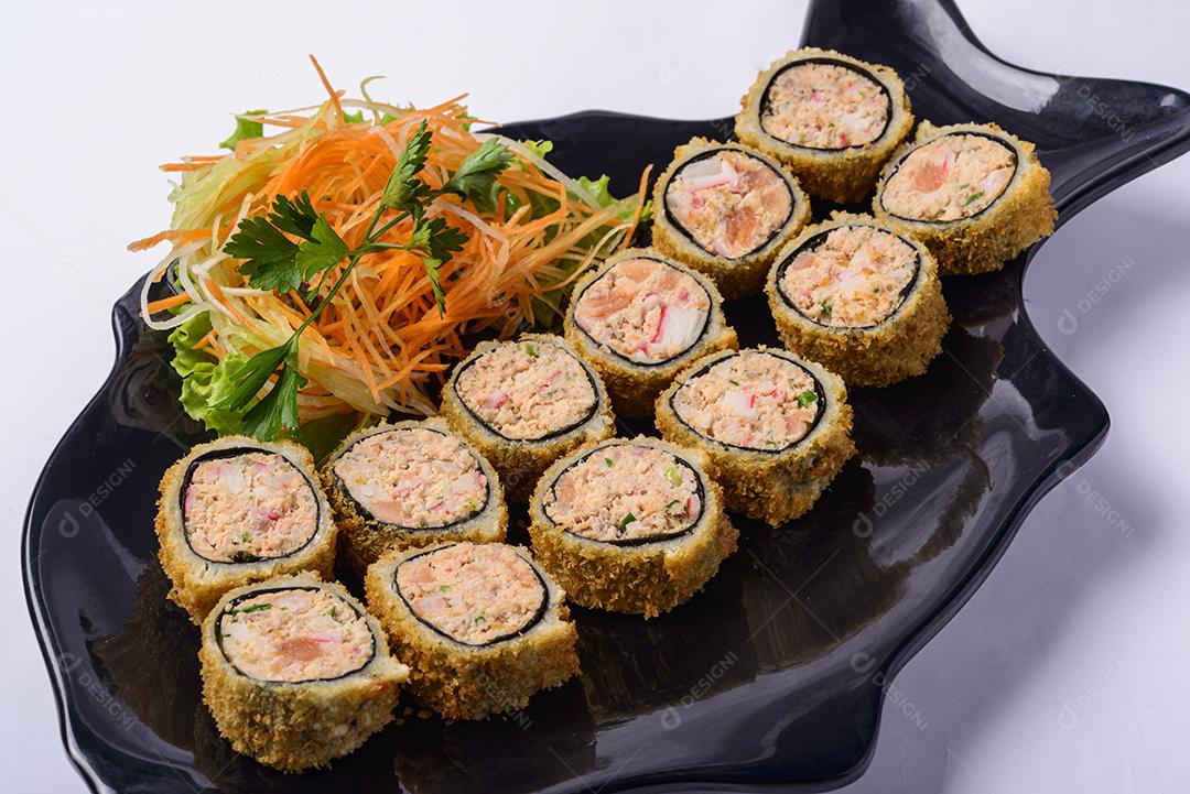 Comida japonesa. Conjunto de rolos de sushi frito em um prato em forma de peixe.