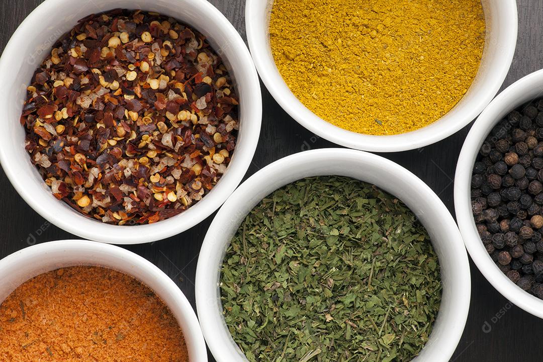 Especiarias coloridas em tigelas.