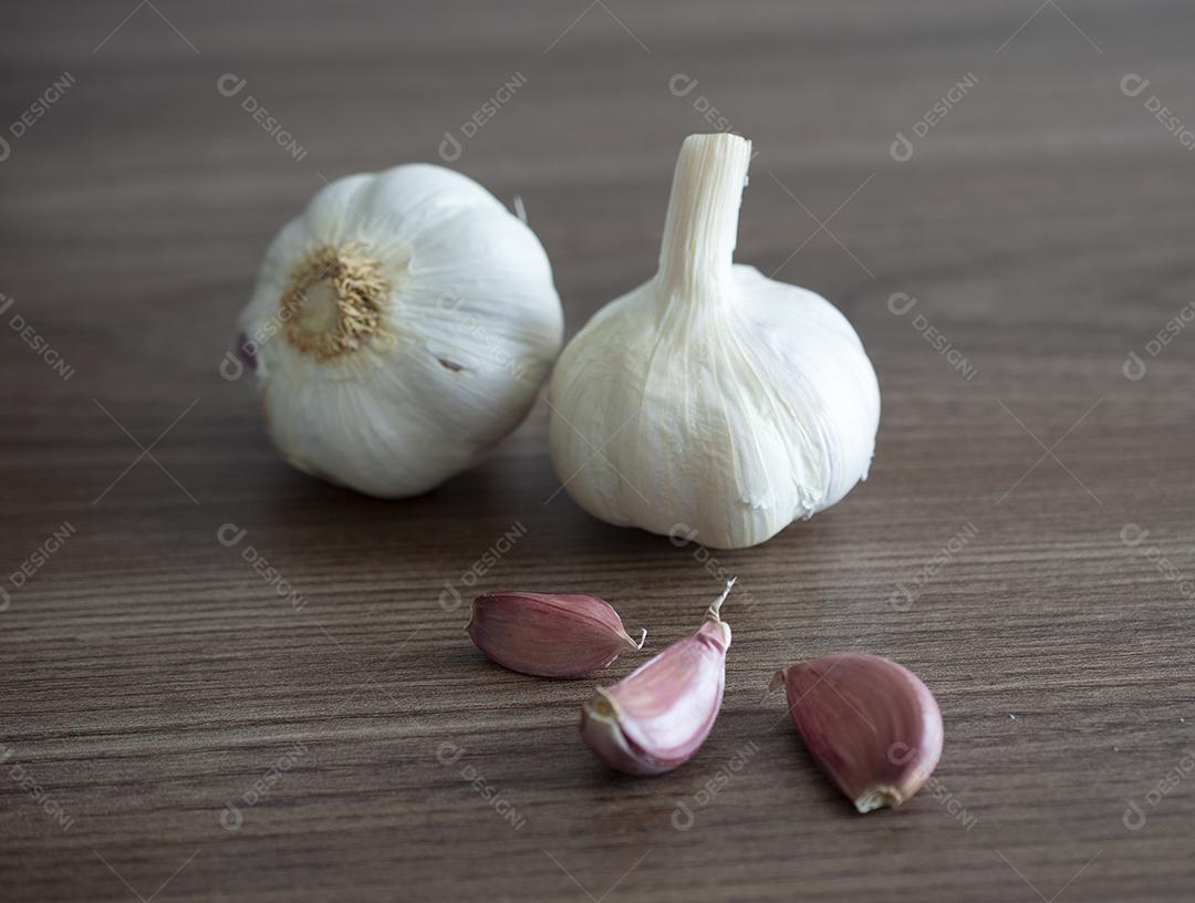 Bulbo de alho e cravo sobre fundo de madeira