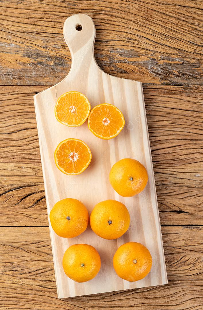 Mini tangerinas em uma tábua sobre mesa de madeira