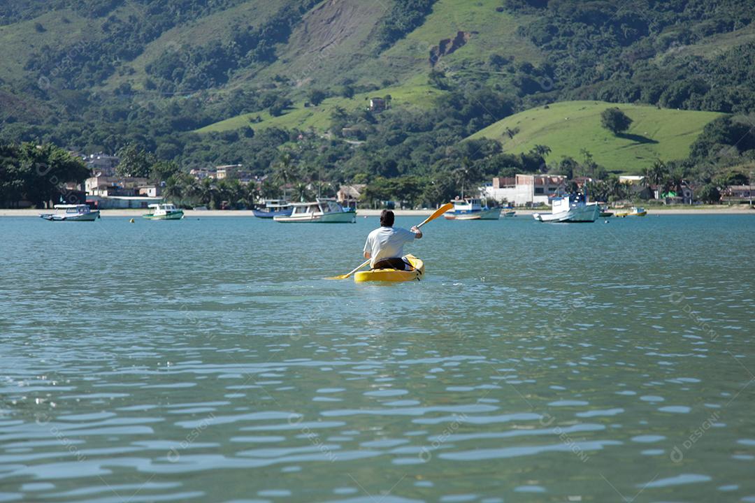 Menino remando caiaque no mar