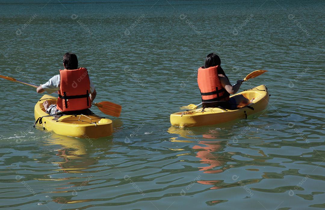 Jovem casal remando caiaque no mar