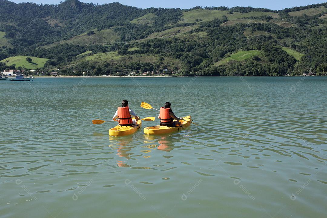 Jovem casal remando caiaque no mar
