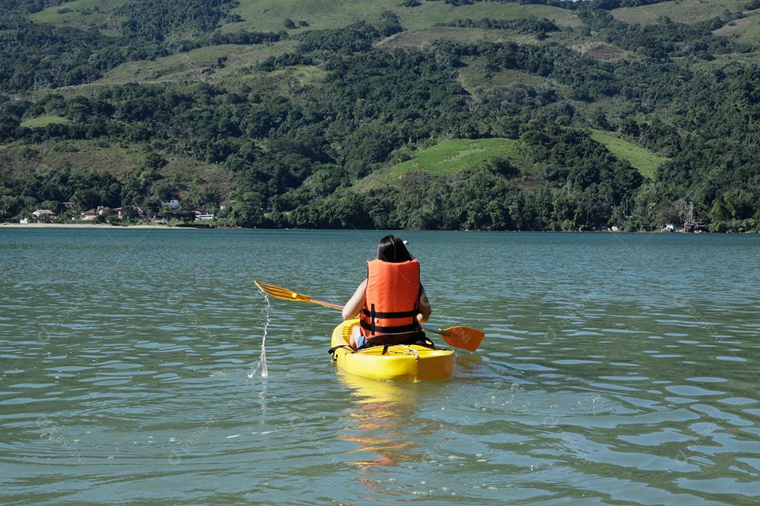 Garota remando caiaque no mar praia