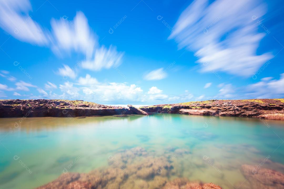 Paisagem de praia tropical com coqueiros e rochas longas exposições