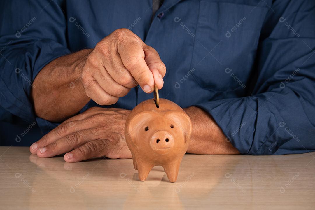 Um homem colocando moedas em cofrinho para economizar dinheiro conceito