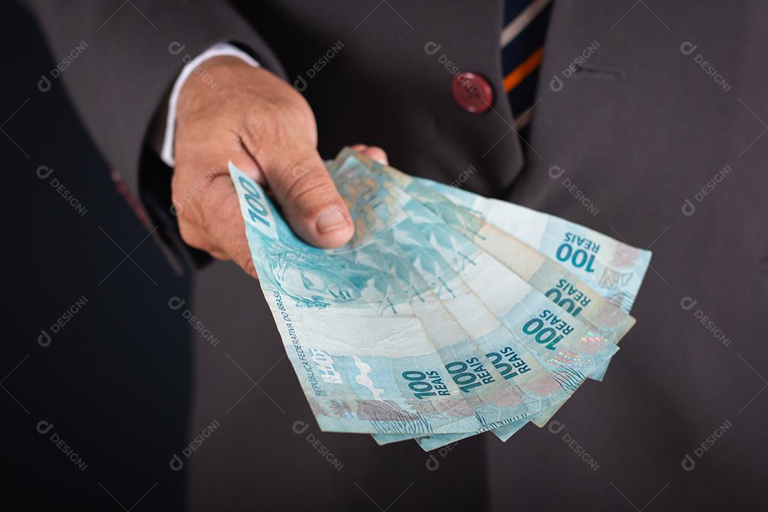 Homem de negócios te mostrando dinheiro brasileiro. conceito de negócio