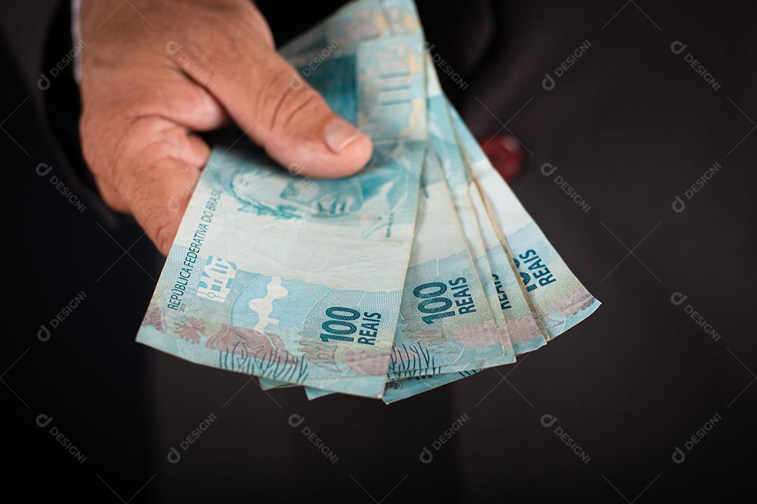 Homem de negócios te mostrando dinheiro brasileiro. conceito de negócio