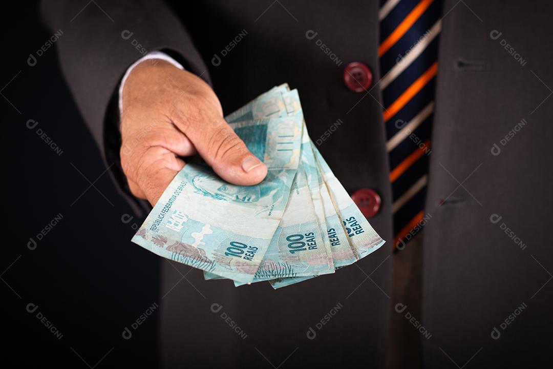 Homem de negócios te mostrando dinheiro brasileiro. conceito de negócio
