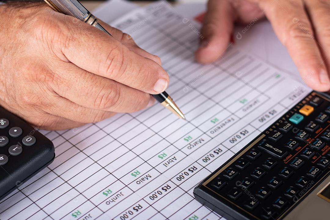 Mãos de contador contando com calculadora