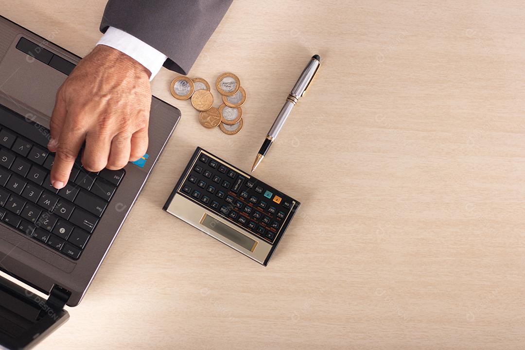 Empresário com computador portátil aberto na mesa digitando