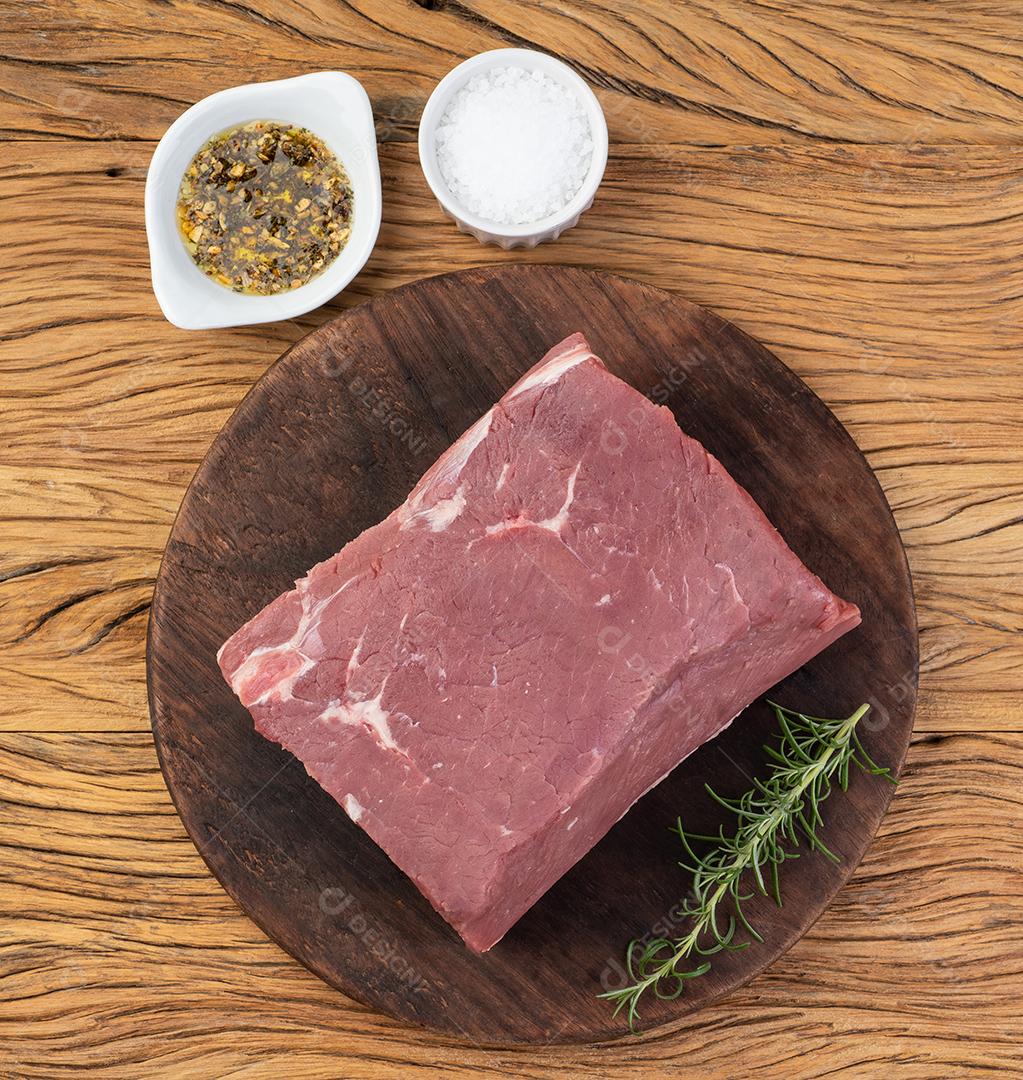 Carne de ancho crua, corte típico argentino, sobre tábua de madeira com temperos.