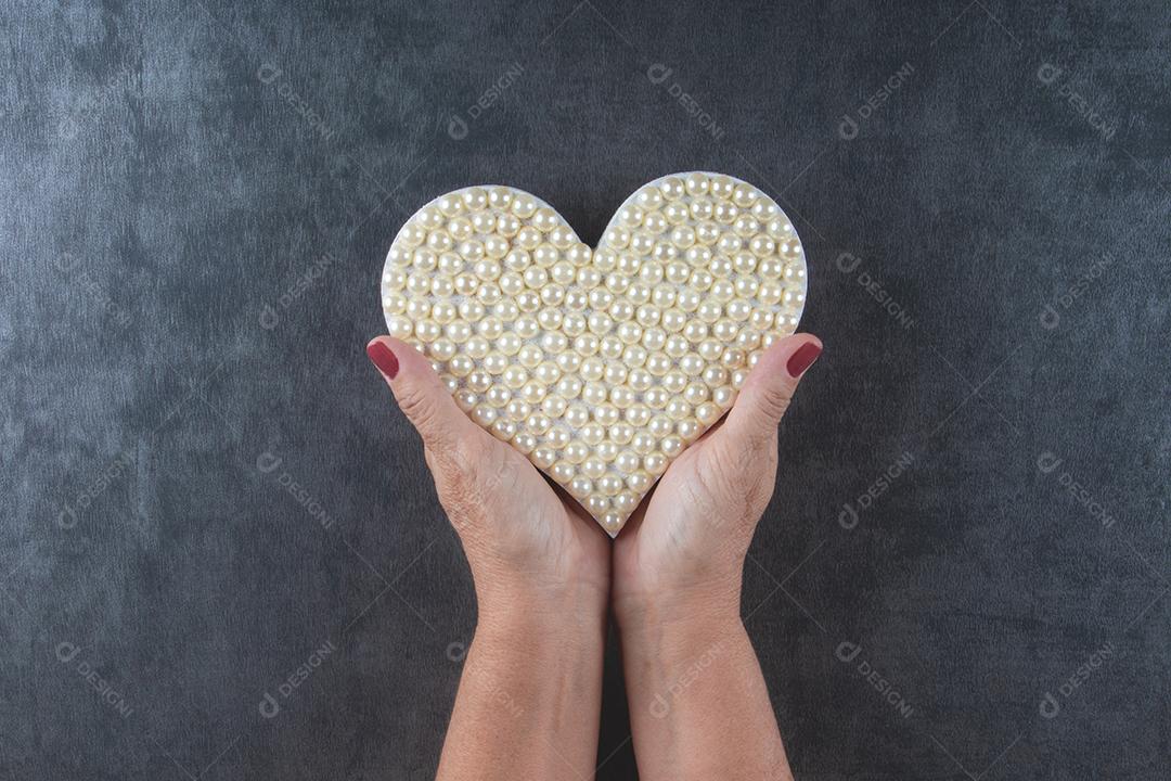 Fundo do Dia dos Namorados com a mão segurando o coração com branco