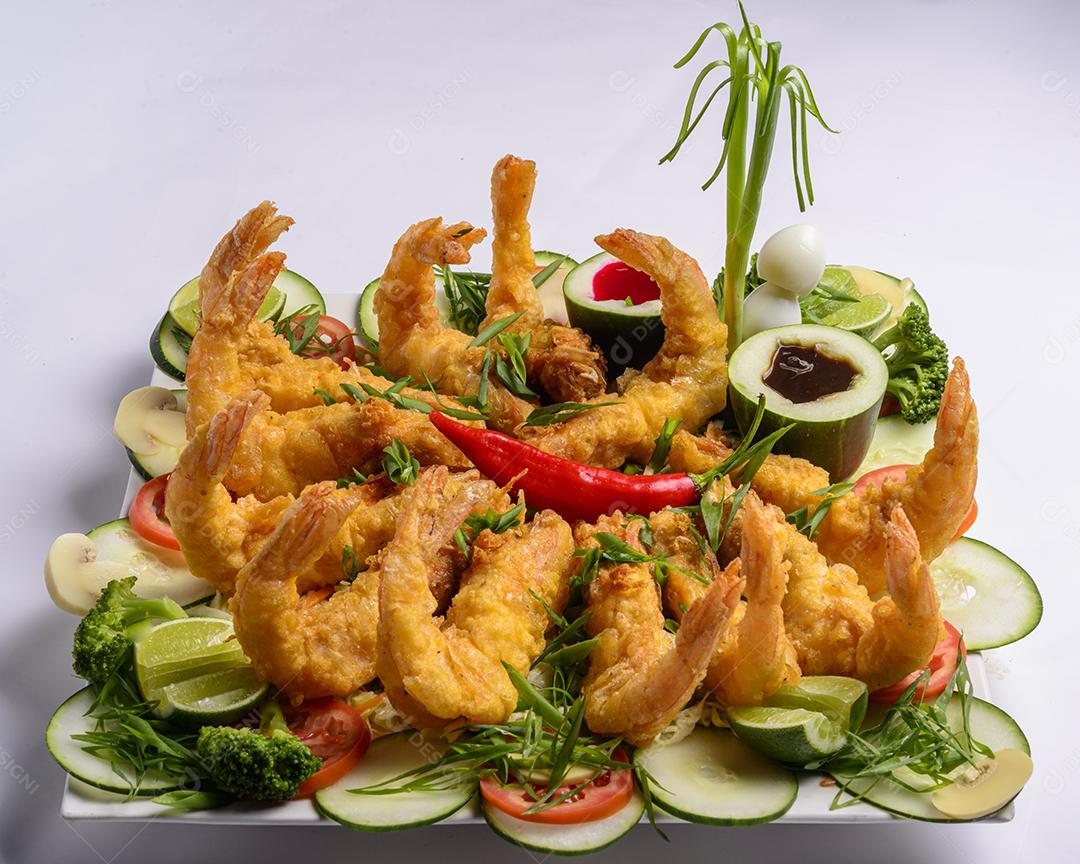 Comida oriental. Camarão crocante frito com legumes no fundo branco